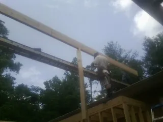 Carpenter setting a ridge beam over a new addition frame — Ice Dam Removal by Roofing Brothers in Panorama City