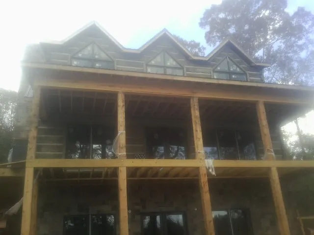 Dormers and porch framing on a large log home under construction — Roof Coating work by our crew in Panorama City
